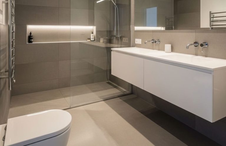 Baño moderno con ducha, lavabo suspendido y decoración minimalista.