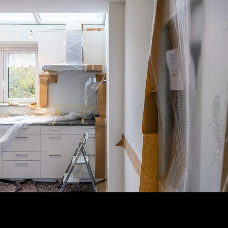 Cocina en proceso de renovación, con utensilios y materiales de construcción visibles.